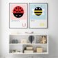 ladybird print and a bee print framed in a babies nursery